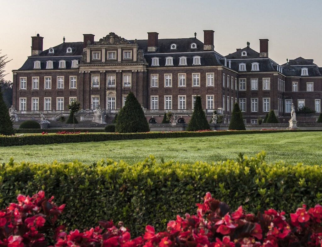 Das Foto zeigt ein Schloss und einen gepflegten Garten