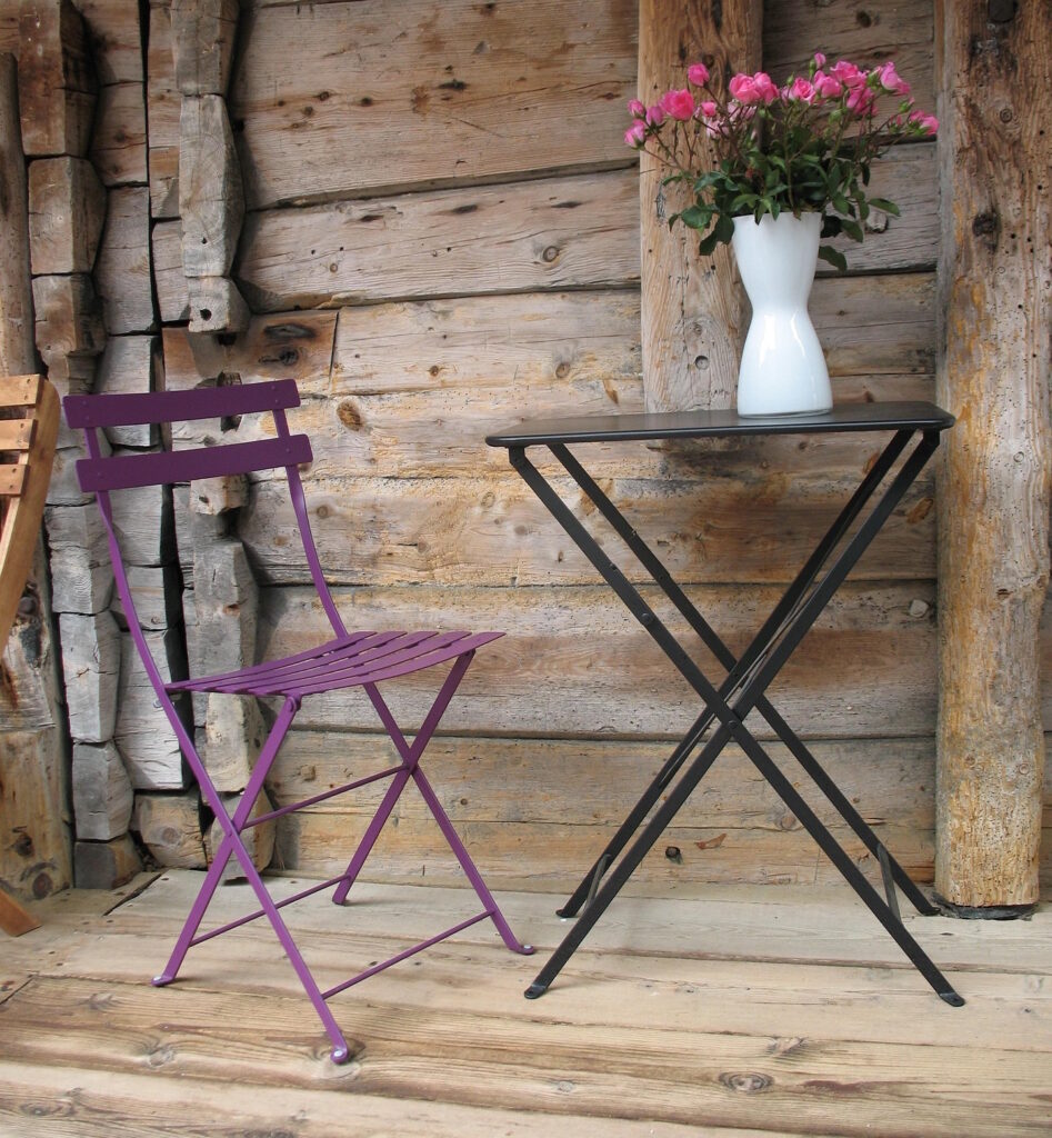 Das Foto zeigt einen Stuhl und einen Tisch auf einem Holzboden