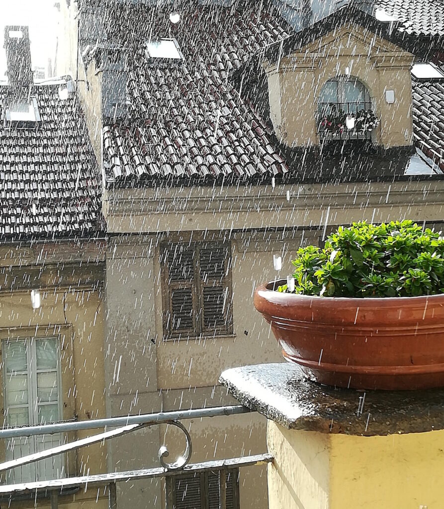 Das Foto zeigt starken Regen von einem Balkon aus gesehen