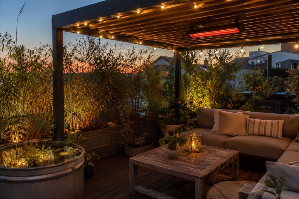Das Foto zeigt eine Terrassenüberdachung und eine gemütliche Atmosphäre mit Kerzen und Couch