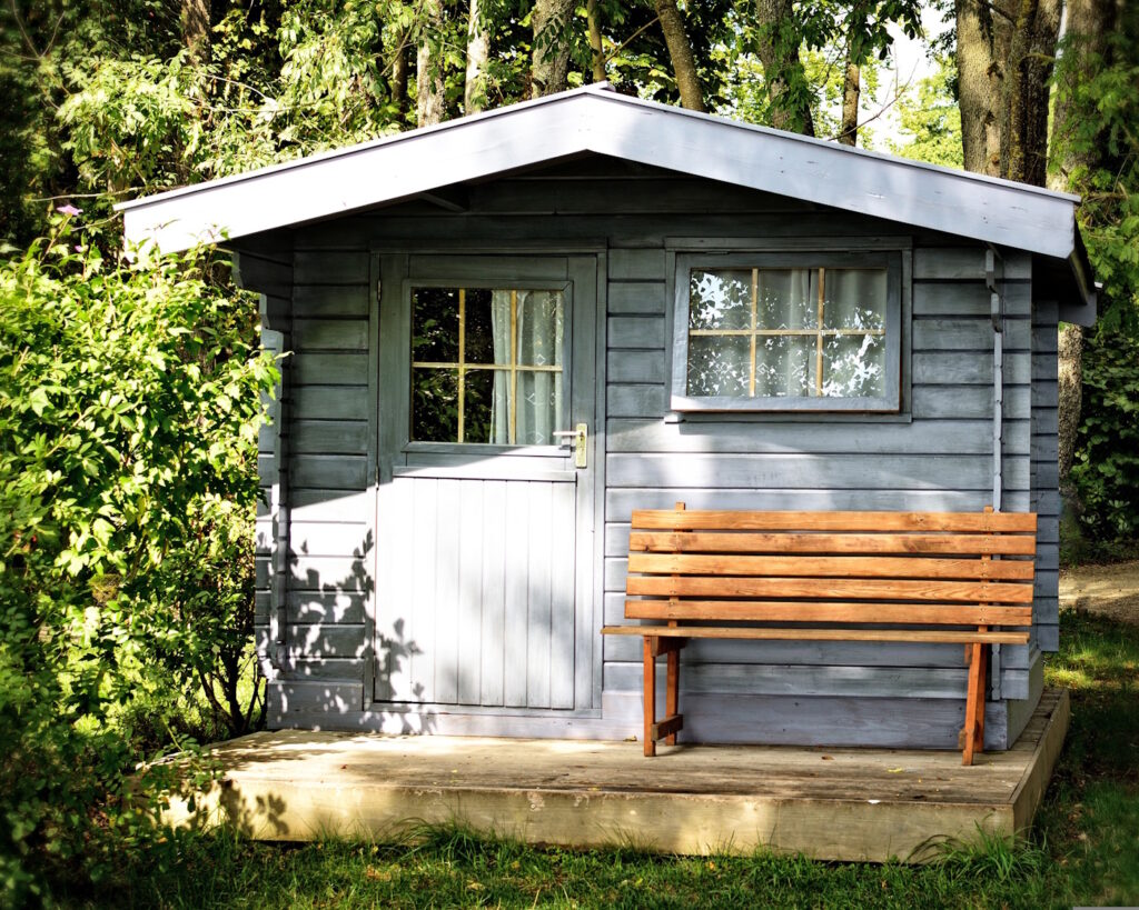 Das Foto zeigt ein Gartenhaus mit Vorhängen