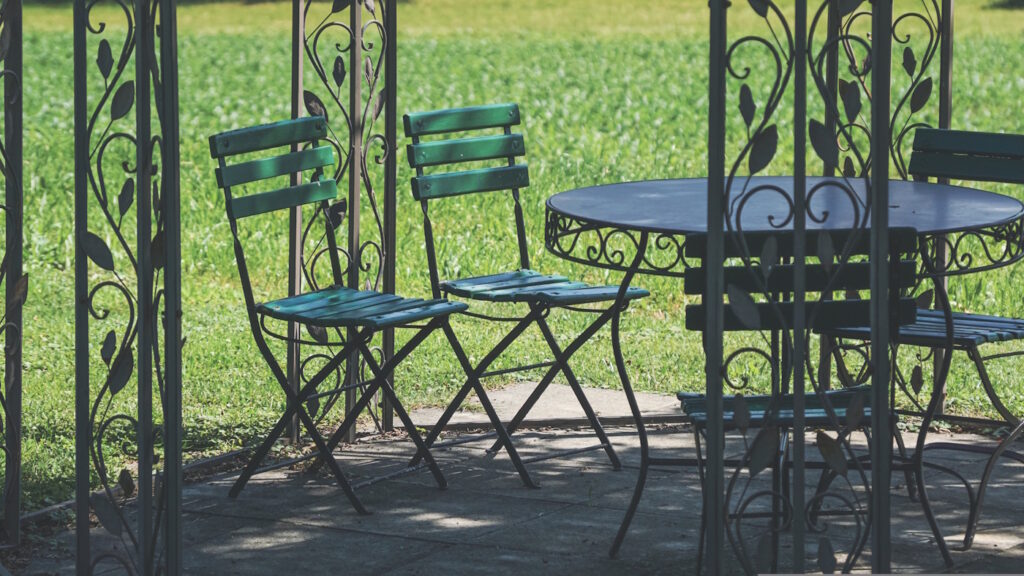 Das Foto zeigt Stühle unter einer Pergola